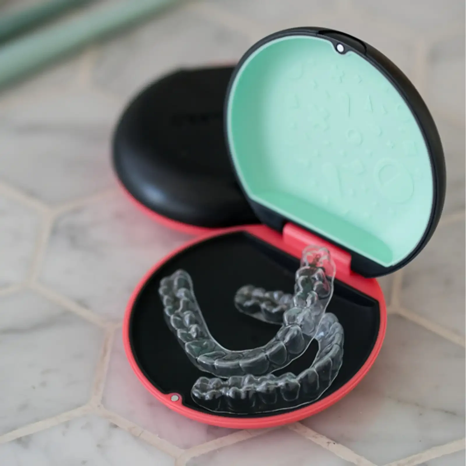 Clear aligner trays resting in an open case