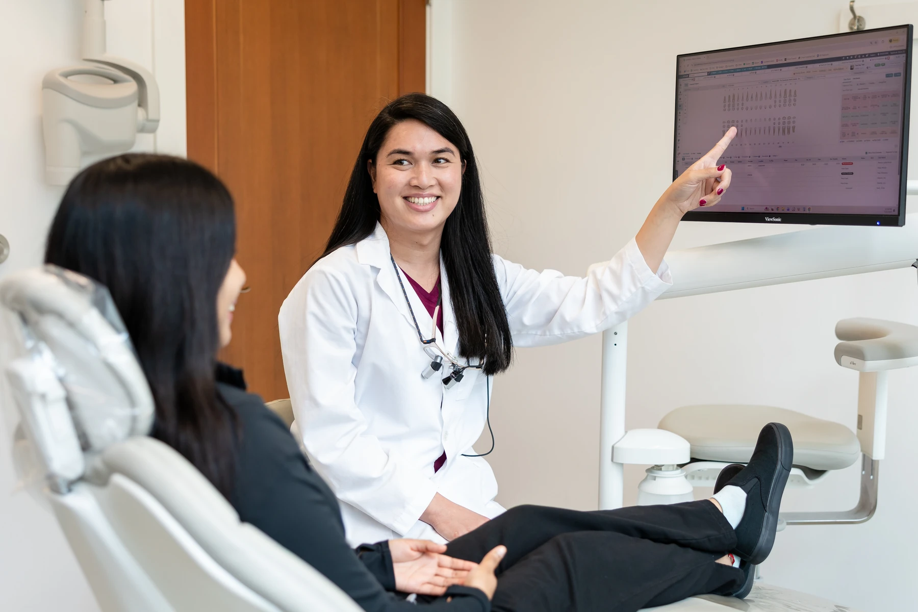 Dr. Sabrina reviewing a treatment plan on screen with a patient