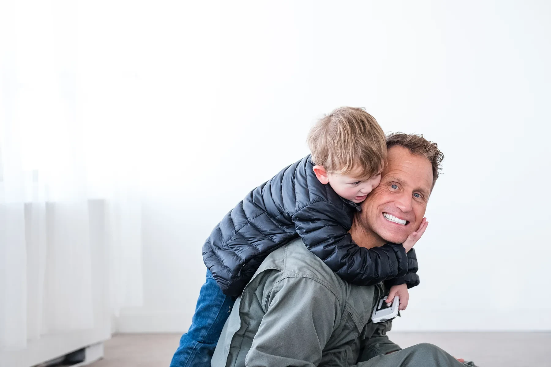 Father carrying his young son on his back outdoors
