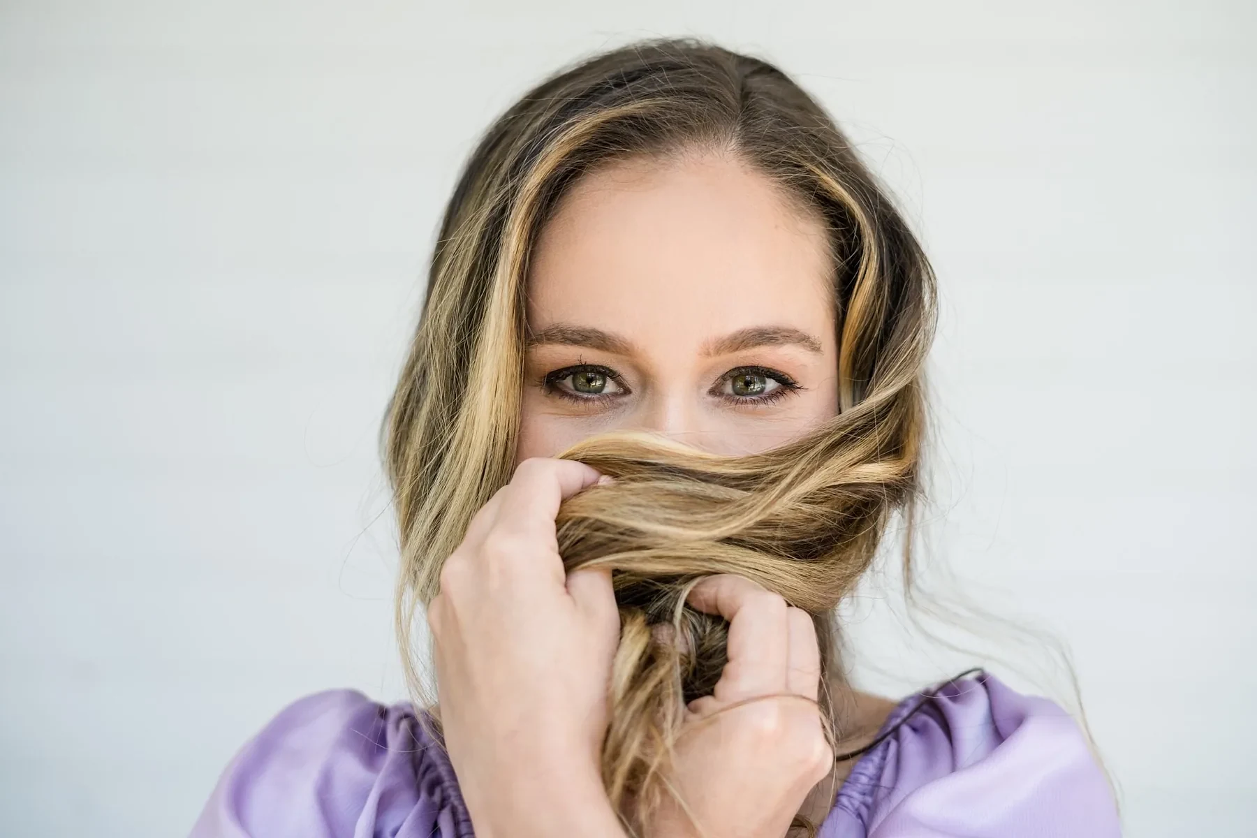 Woman partly hiding her smile behind her hair