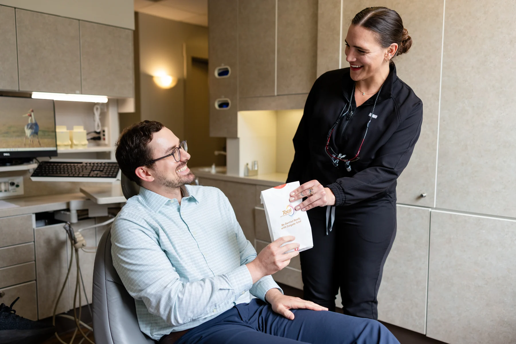 Team member handing a patient a take-home whitening kit