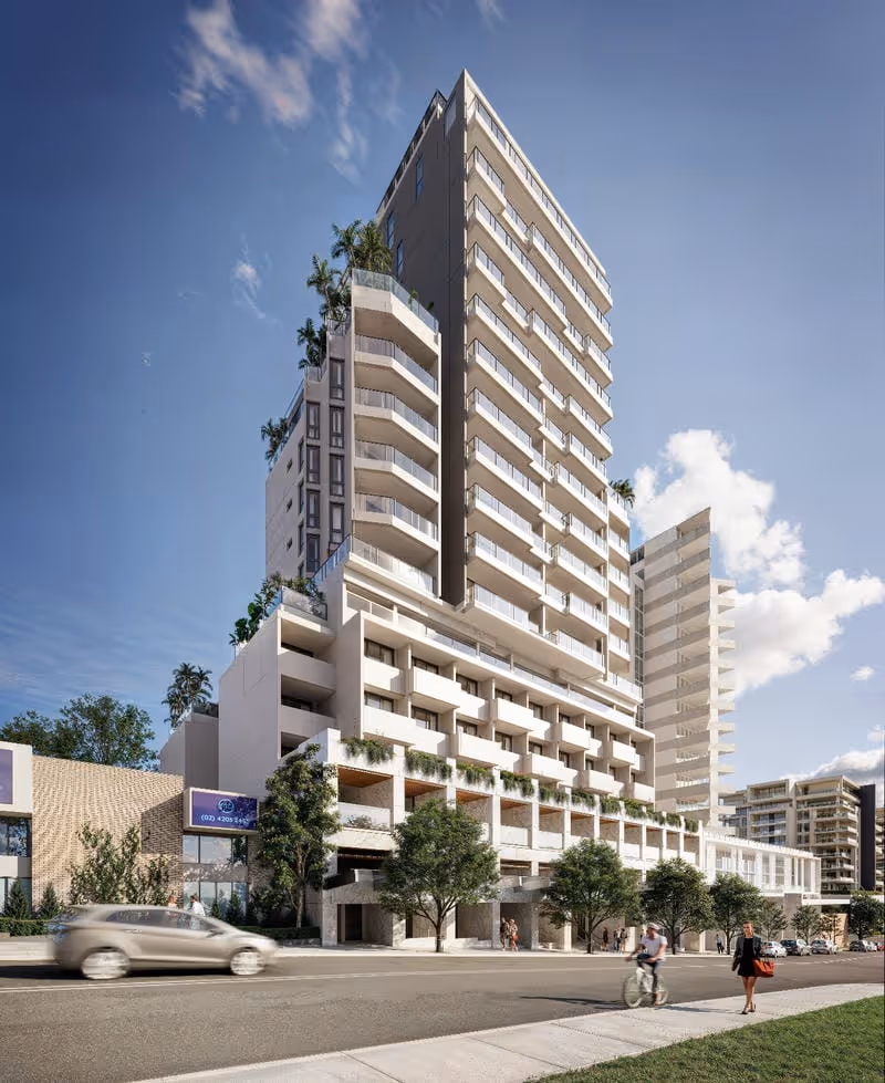 Modern multi-storey apartment building with balconies, greenery, and people nearby on a sunny day.