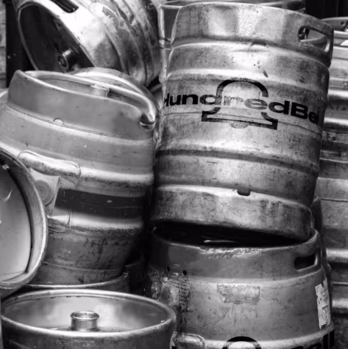 Stacked steel beer kegs with some visible branding in a black and white photo. (Claudio Divizia, Vecteezy)