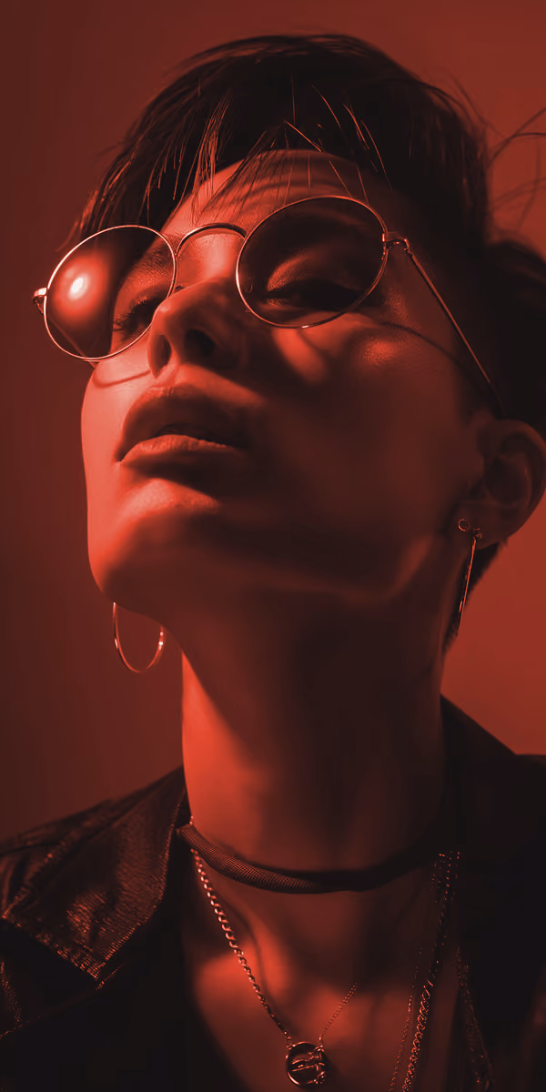 Side-profile portrait with the face split by warm red and cool blue lighting
