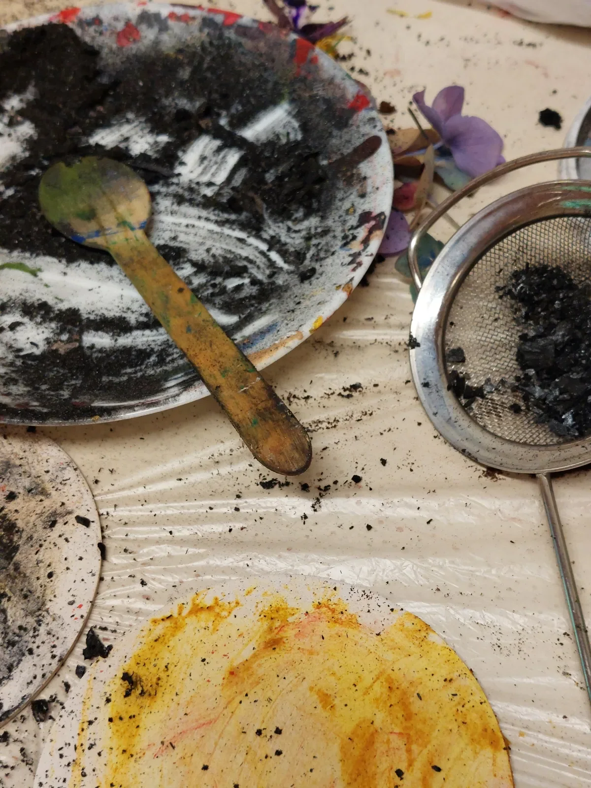 Arbeitsmaterialien für Kunst auf einer Tischdecke.