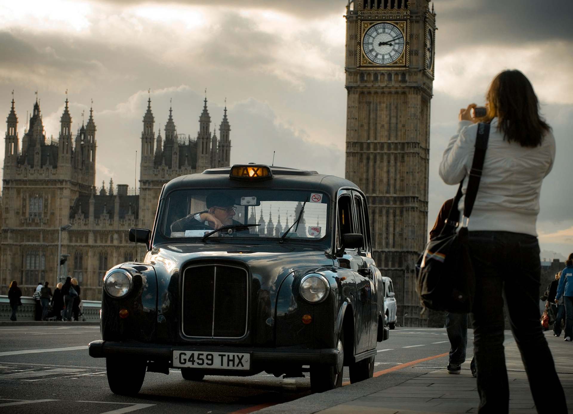 A London black cab crossing Westminster Bridge with Big Ben and the Houses of Parliament behind