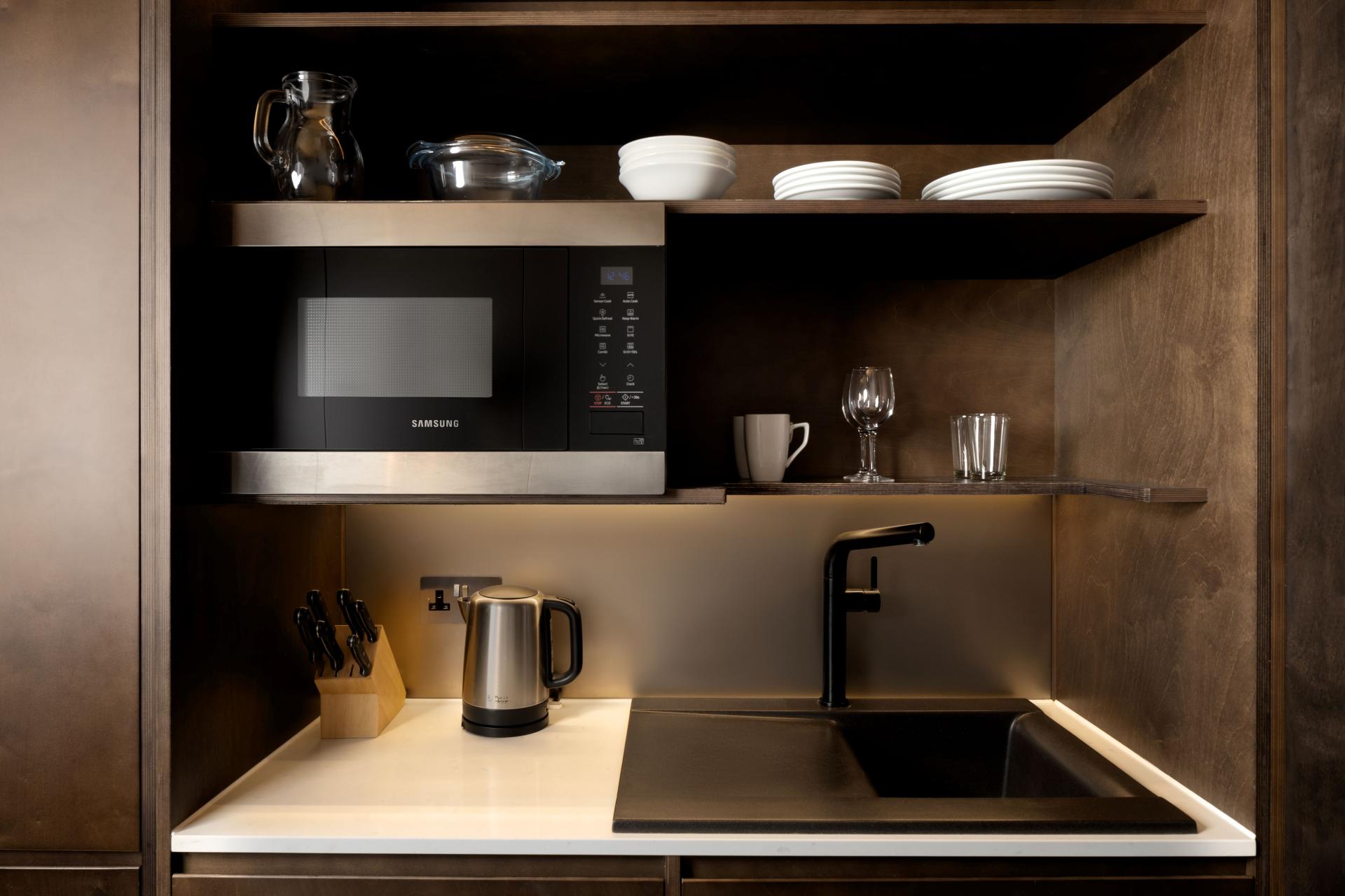 Kitchenette with microwave, kettle and fridge in a Stow Away studio
