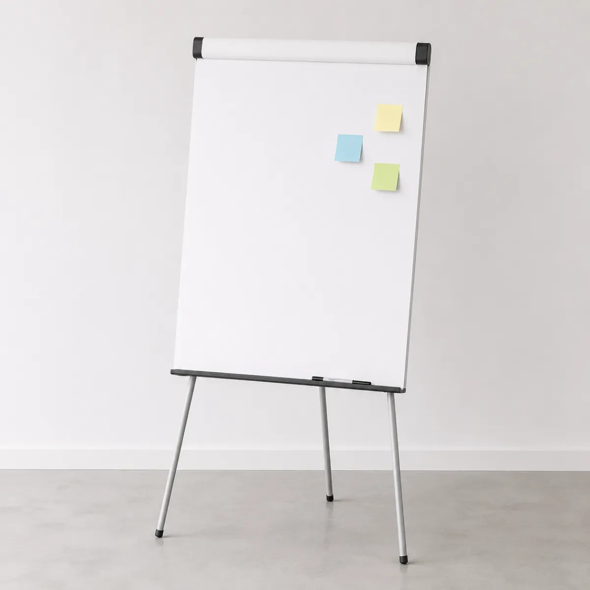 Leeres Flipchart mit drei bunten Haftnotizen in Blau, Gelb und Hellgrün an der rechten oberen Ecke.