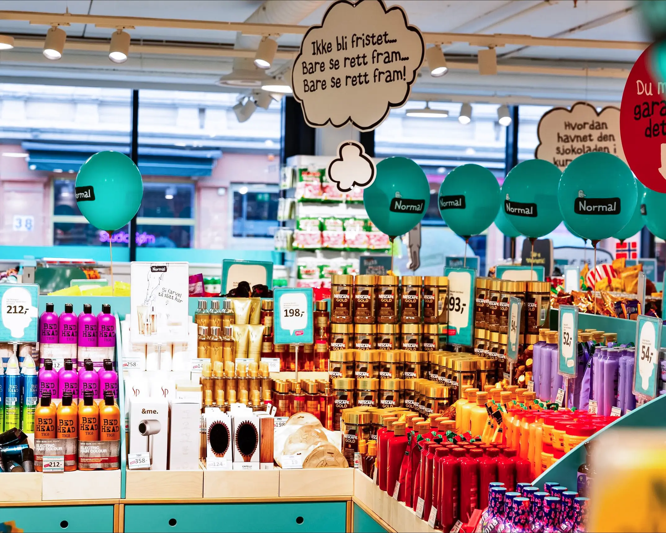 Store shelves displaying colorful hair care and beauty products with teal balloons labeled 'Normal.'