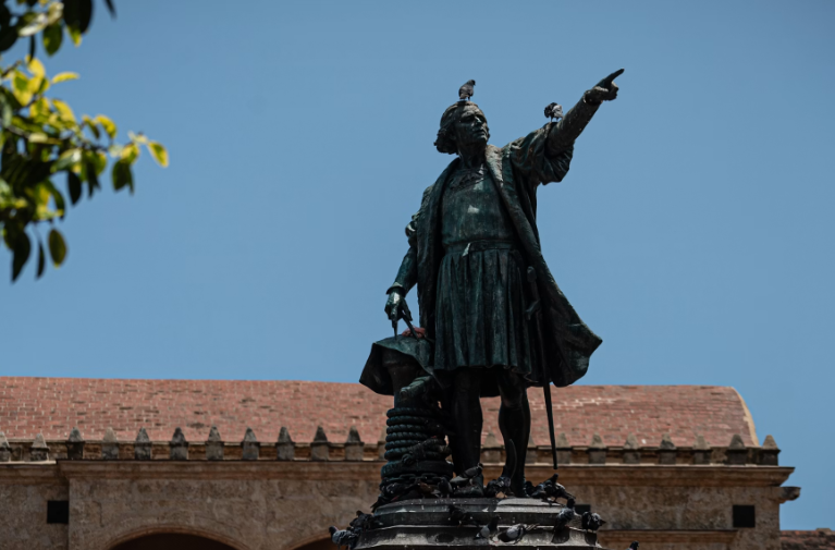 Bronze statue on a cobbled colonial street.