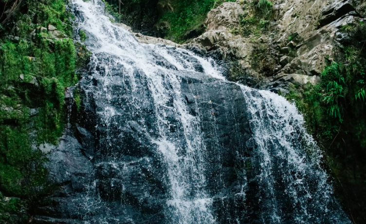 Tall jungle waterfall dropping into a natural pool.