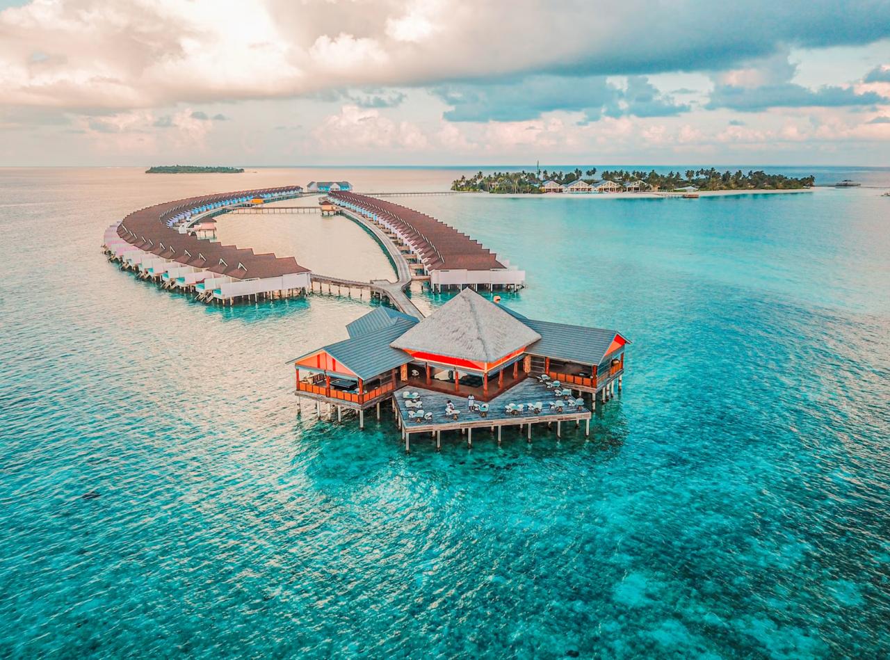 Overwater bungalows above clear turquoise Maldives lagoon