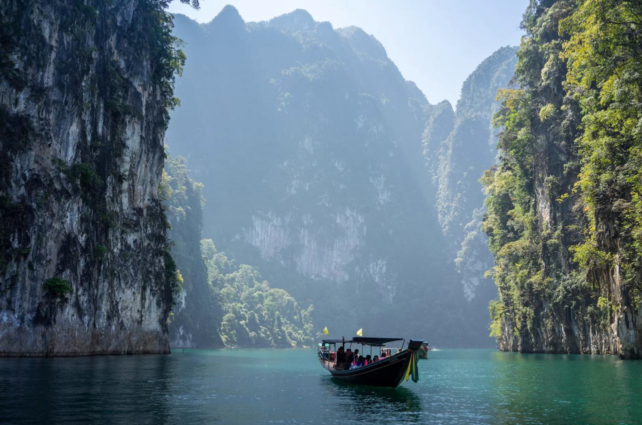 Longtail boats beneath Krabi limestone cliffs Thailand
