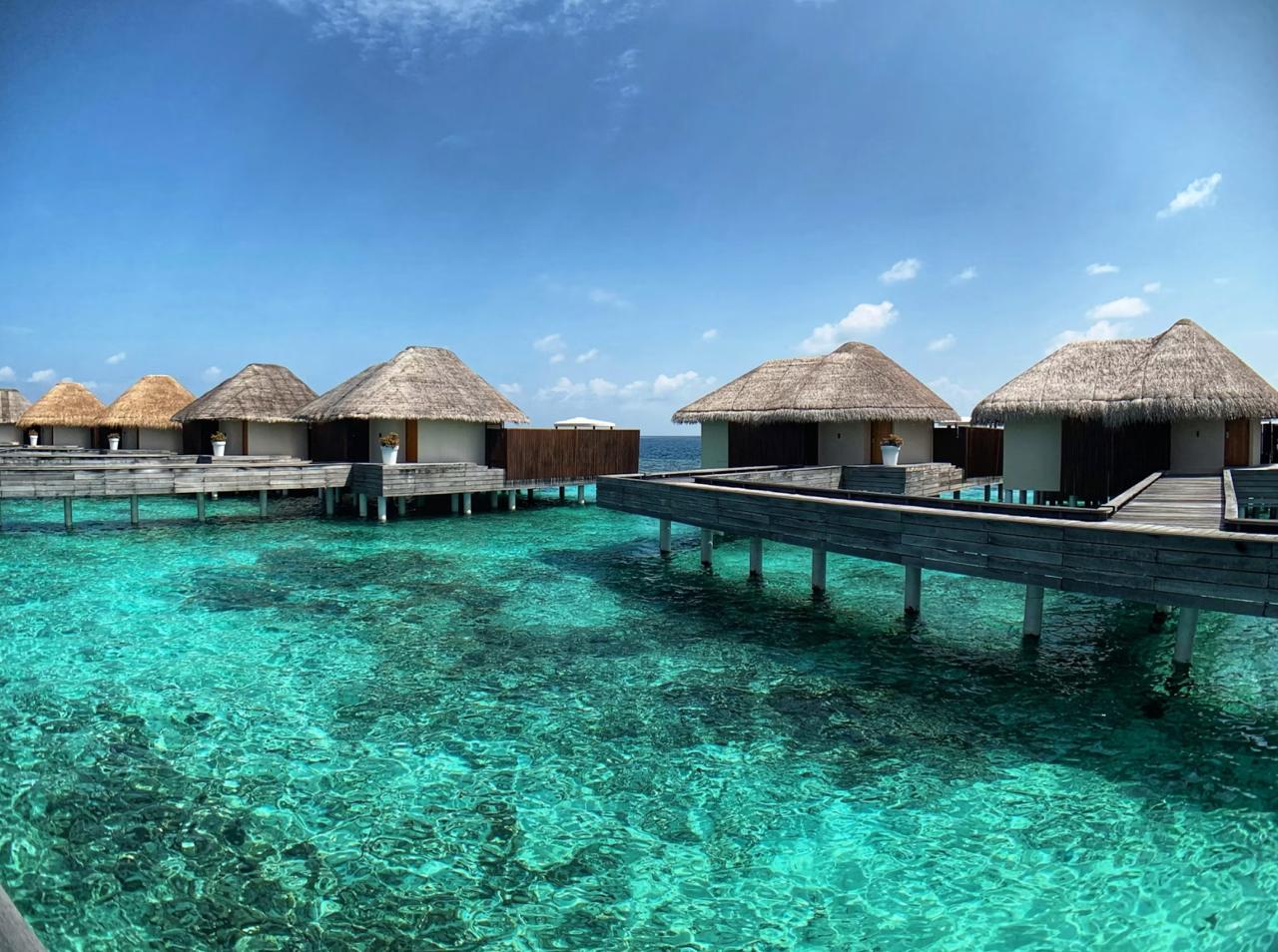 Overwater villas above turquoise Maldives lagoon water