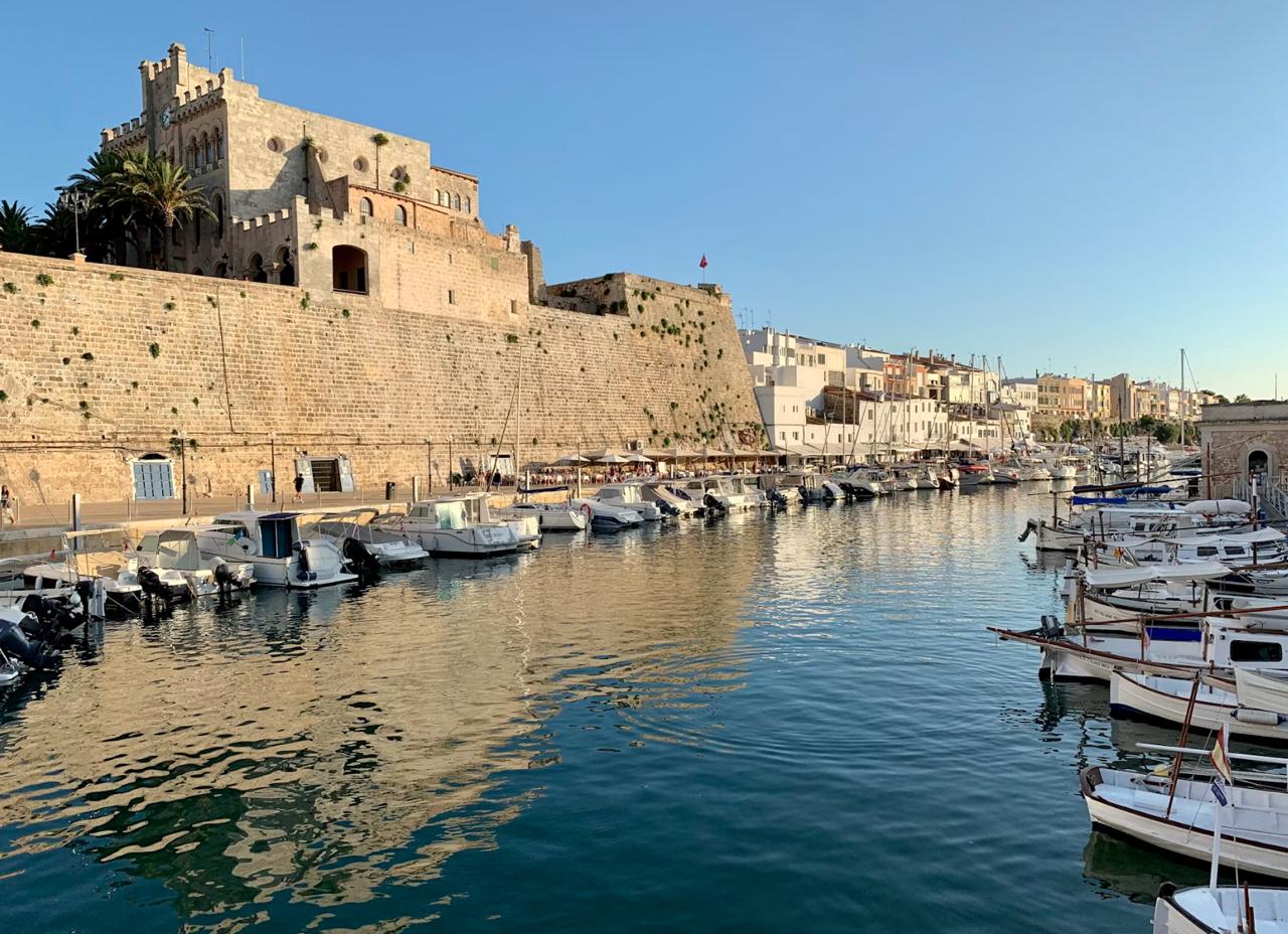 Historic stone fortress above harbour with small white boats