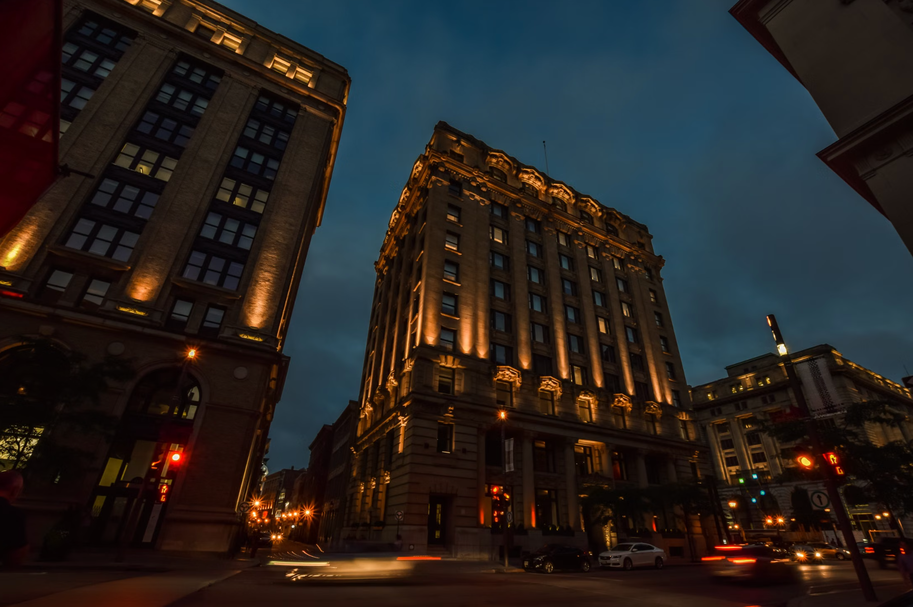 Large historical figure projected onto a stone building wall in Old Montreal at night as part of Cité Mémoire