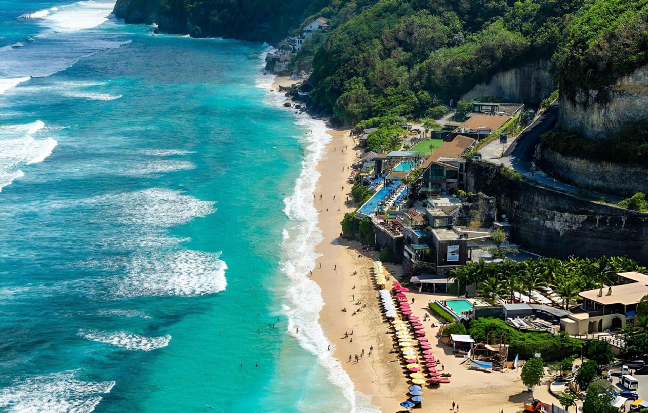 Aerial view of beautiful Melasti Beach in Bali featuring turquoise water and beach clubs