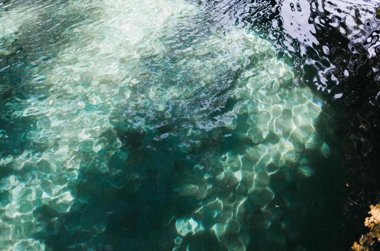 A mesmerizing view of clear water reflecting sunlight patterns, creating a tranquil aquatic scene.
