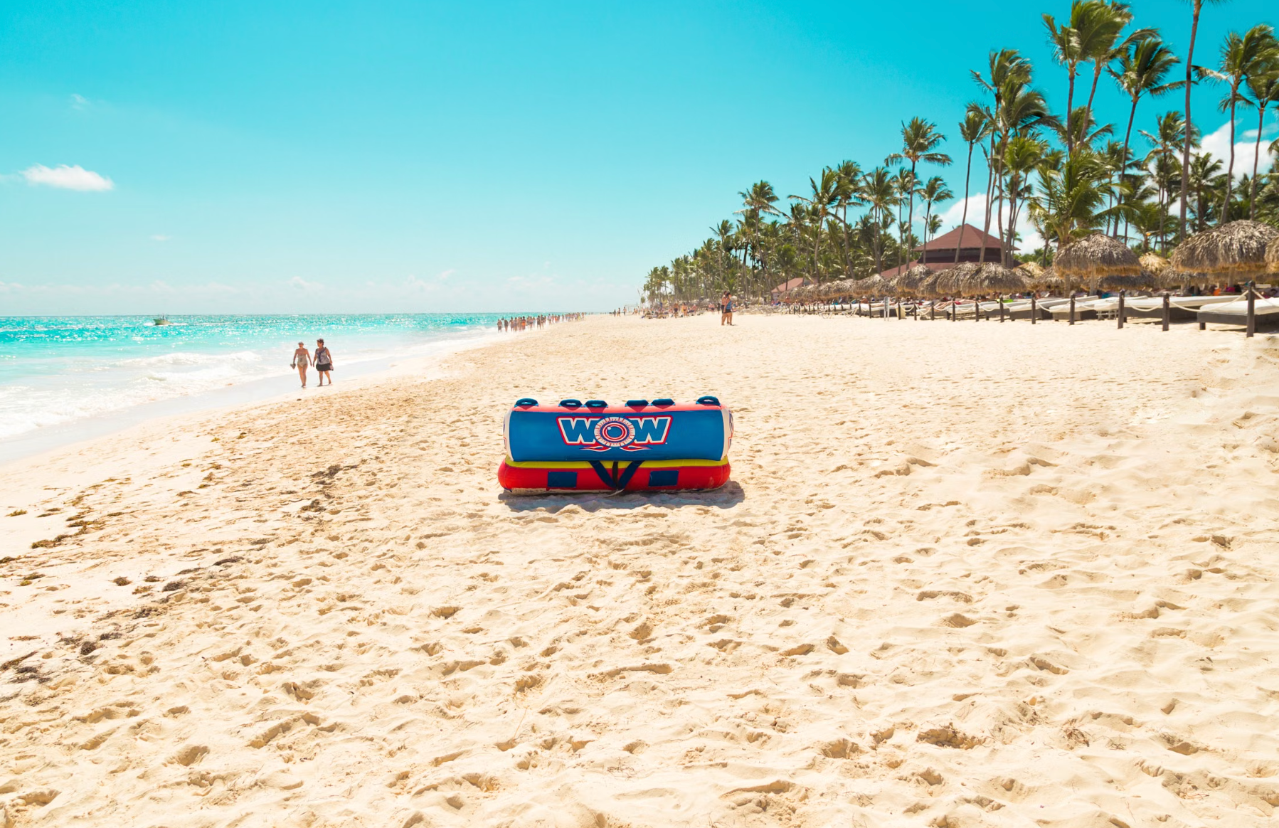 Calm, well-kept gated resort beach in Punta Cana with a lifeguard stand and a few relaxed visitors, reflecting the high safety of the main resort zones