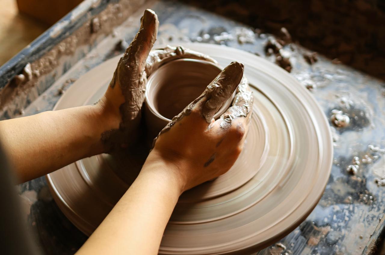 Hands creating pottery on wheel at Nusa Clay Club workshop in Canggu