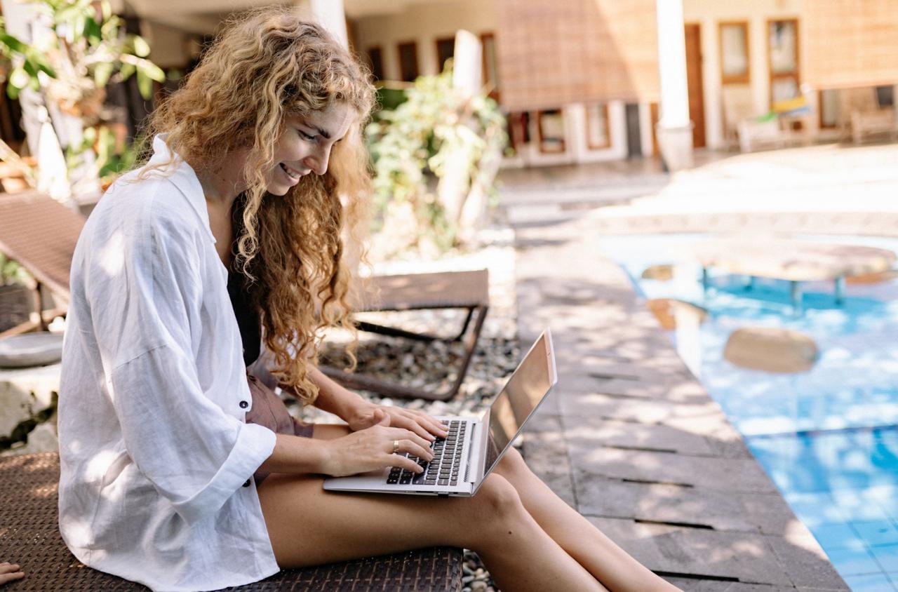 Digital nomad working at poolside coworking space in Canggu tropical setting