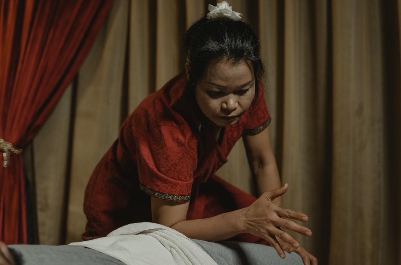 Traditional Balinese massage therapist treating client at spa in Canggu
