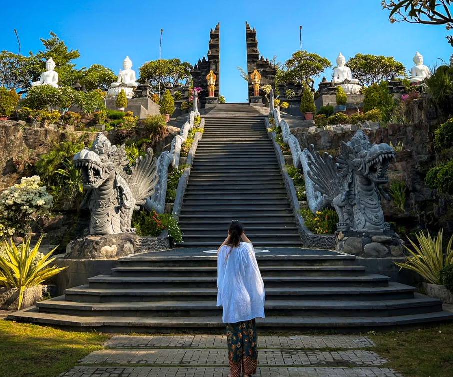Solo female traveler ascending Balinese temple staircase peacefully