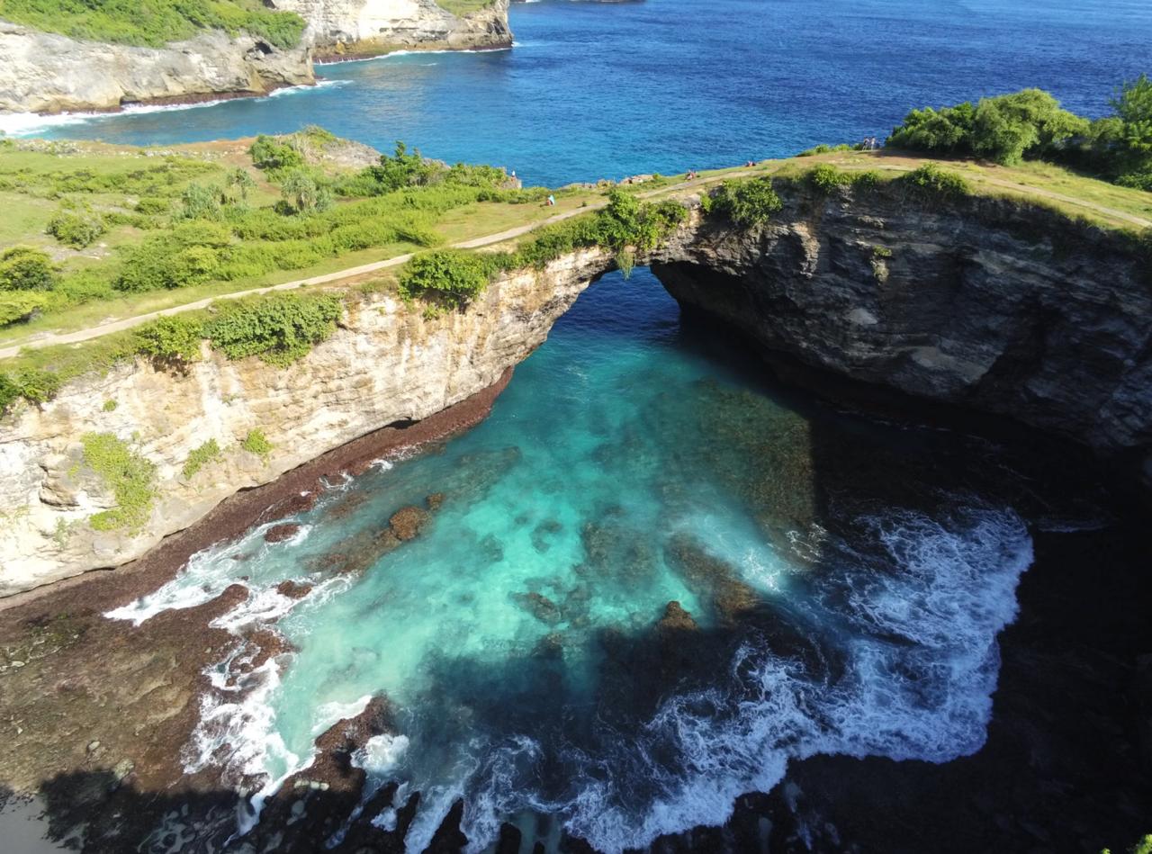 Natural stone archway frames turquoise lagoon Broken Beach Indonesia