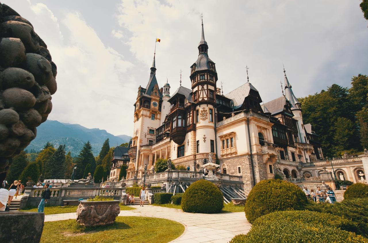 Turreted Neo-Renaissance towers of Peleș Castle framed by pine-covered Carpathian slopes
