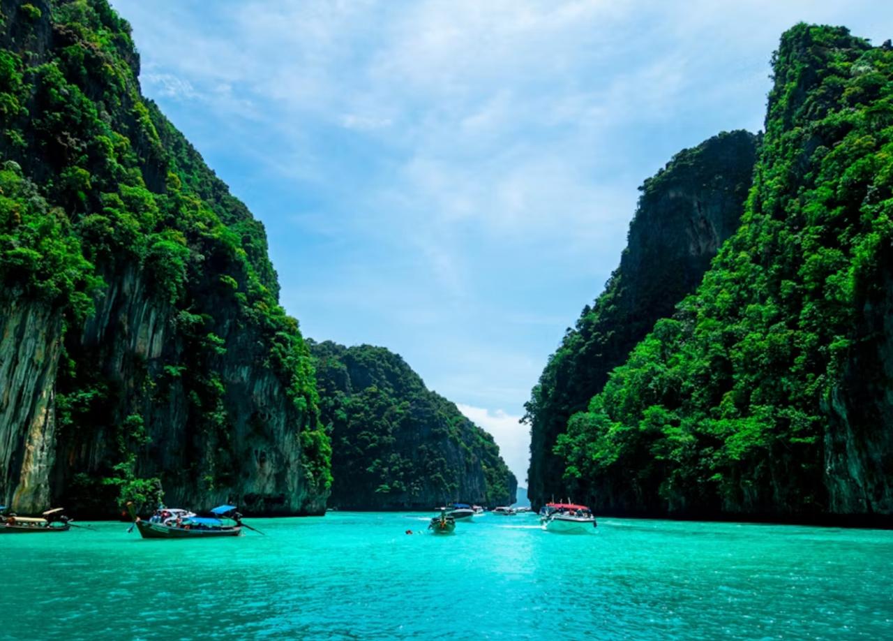 Longtail boat floating beside a turquoise tropical beach in Phuket.