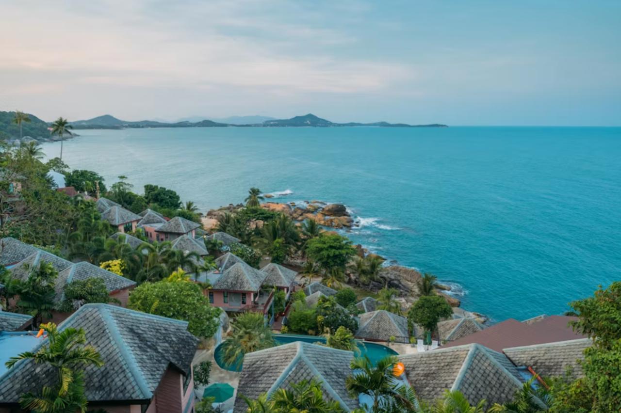 Palm trees surrounding a peaceful sandy shoreline in Koh Samui.