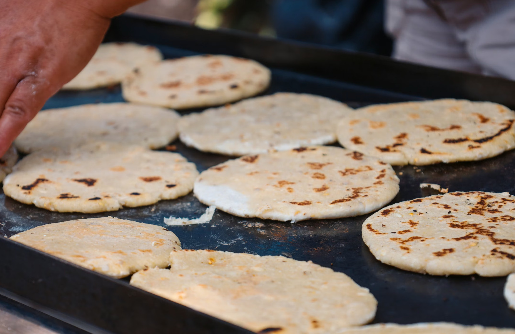 Griddled pupusas topped with curtido and salsa at a market in Juayúa, El Salvador