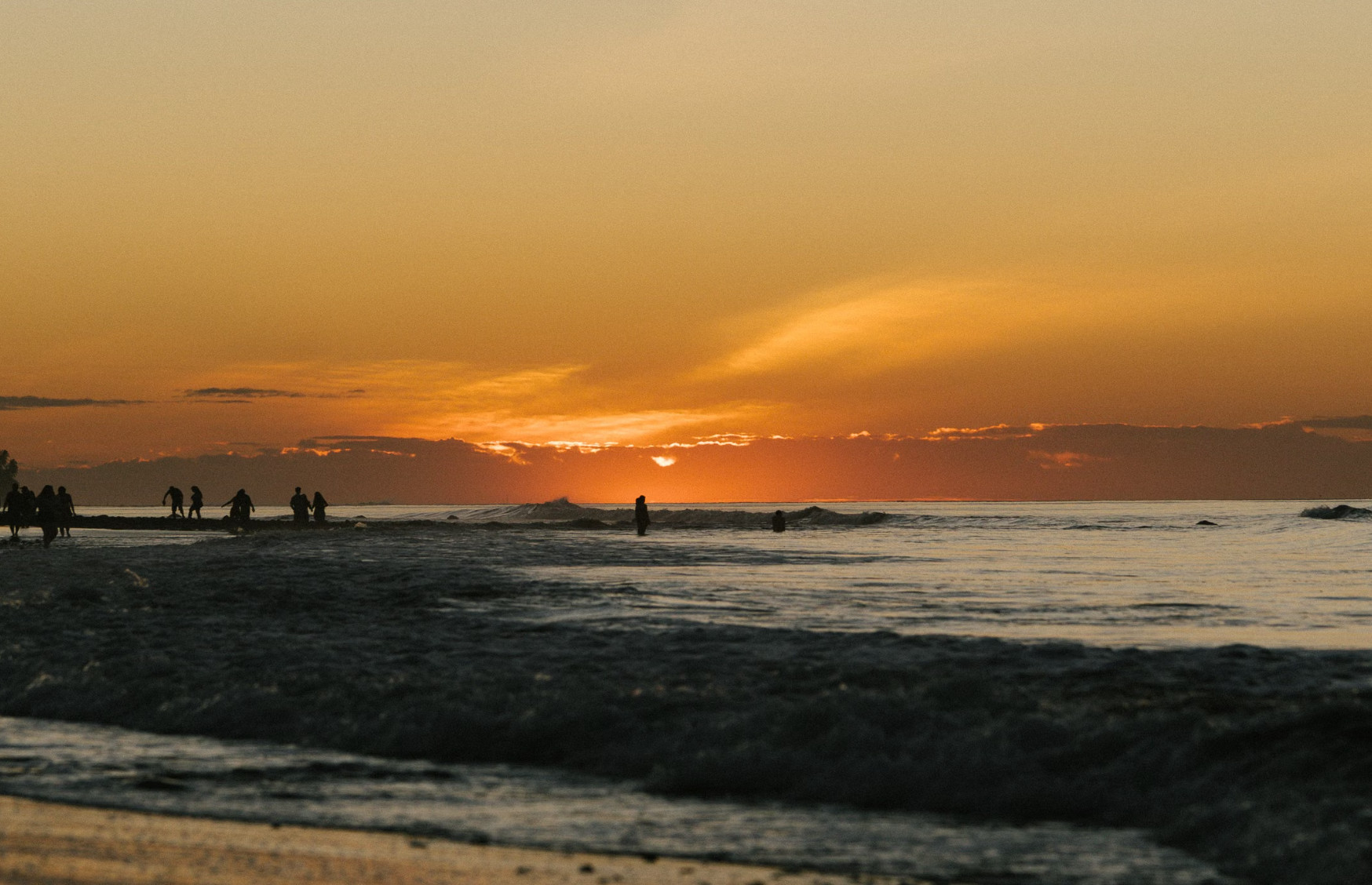 Surfer riding a wave at sunset off El Tunco beach, El Salvador