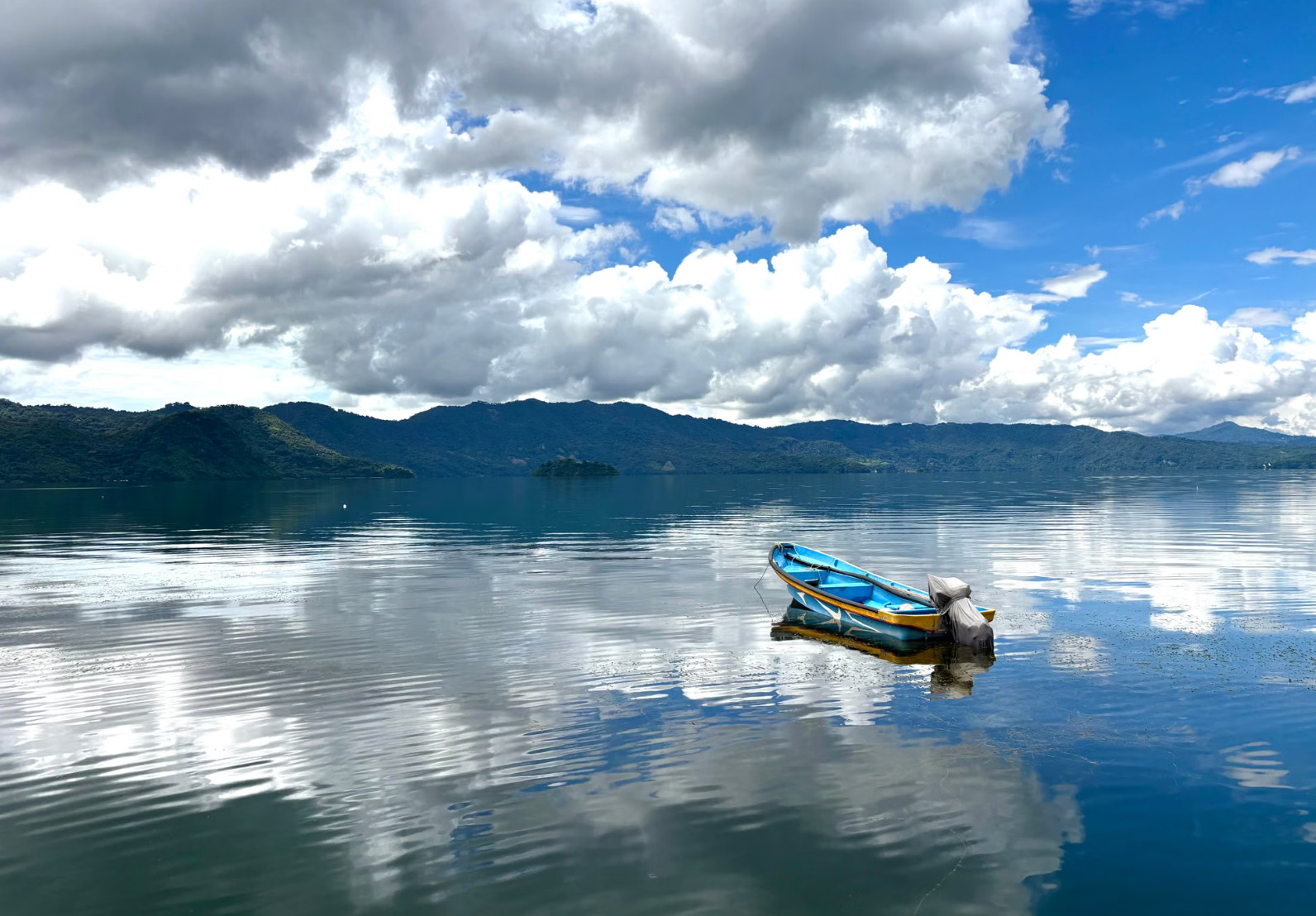 Deep blue Lake Coatepeque crater lake beneath green volcanic slopes, El Salvador