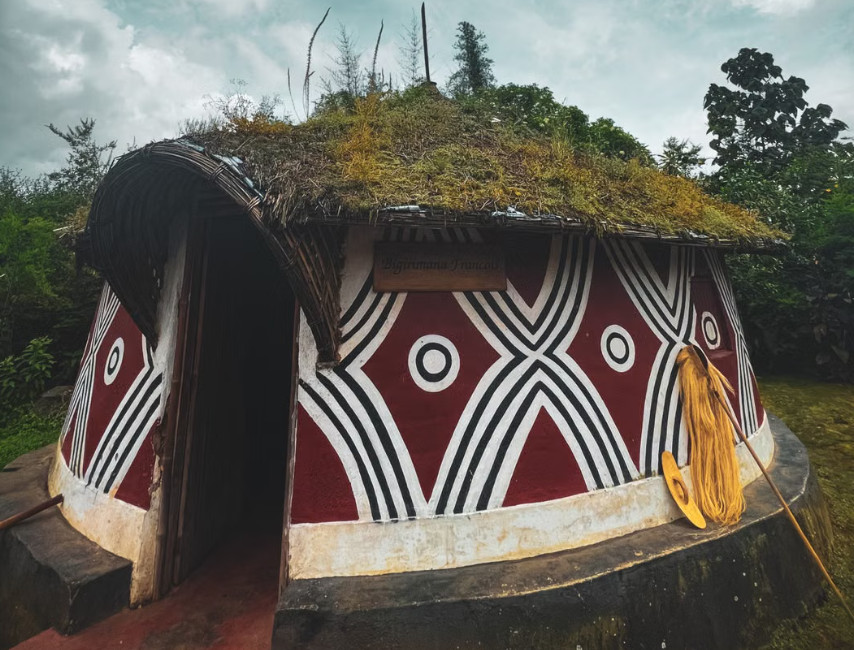 Painted red and white Emberá village hut with patterns