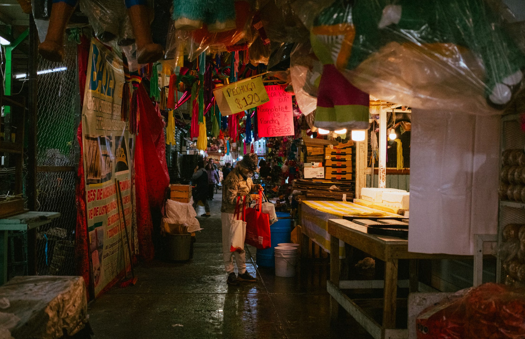 Shopper browsing a busy covered local market at night