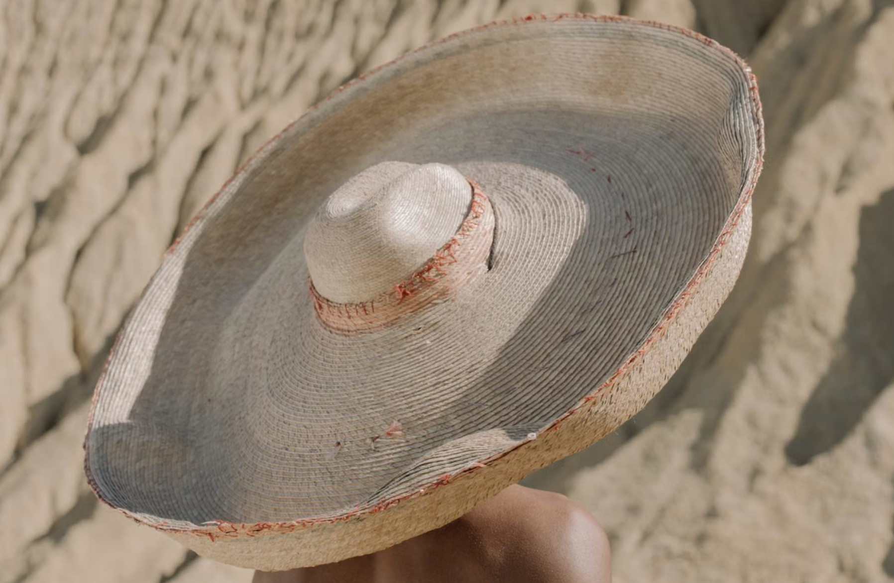 Handwoven Panamanian sombrero pintao straw hat held in sunlight
