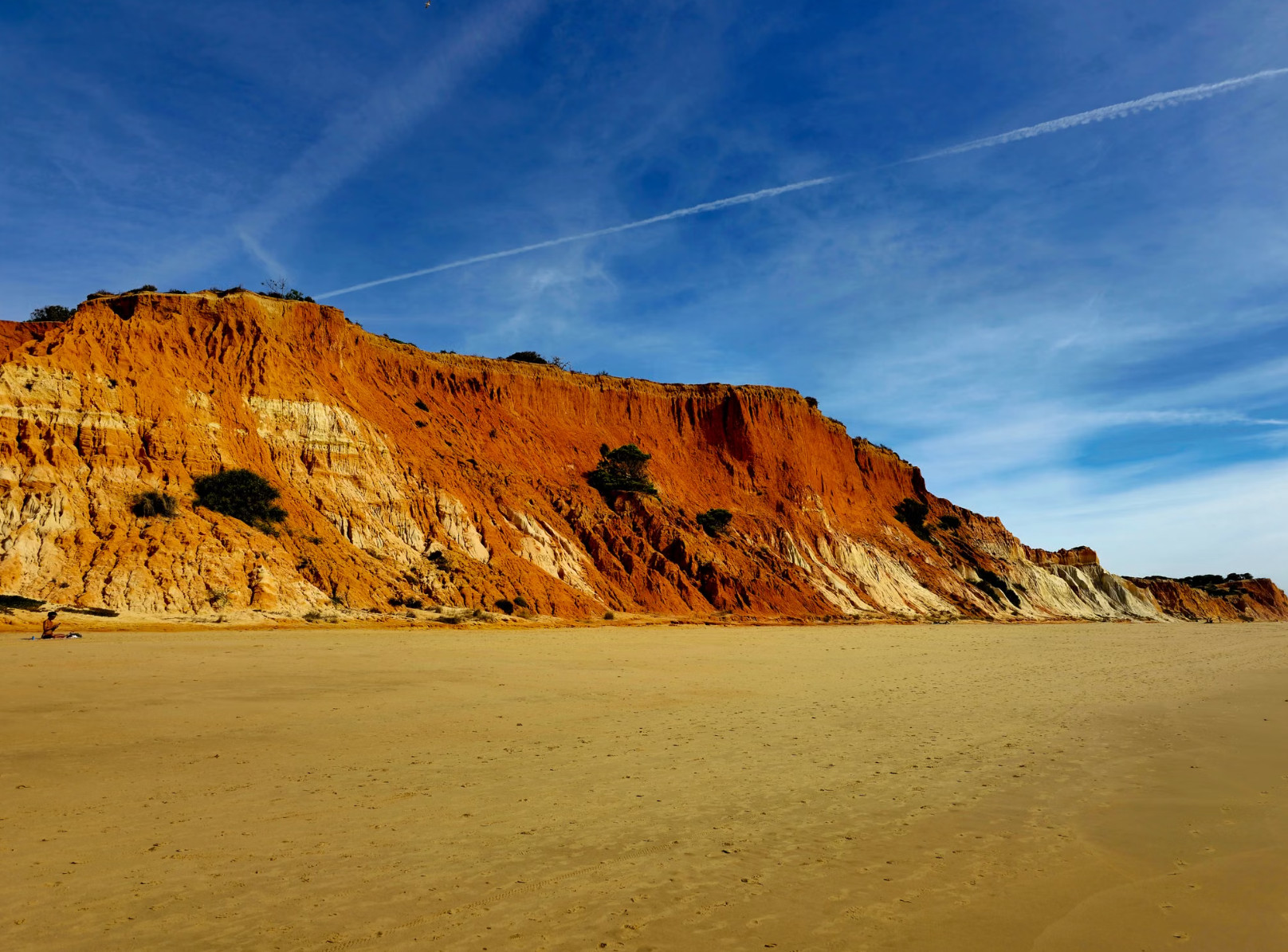 Orange cliffs above empty sand at Praia da Falésia Algarve
