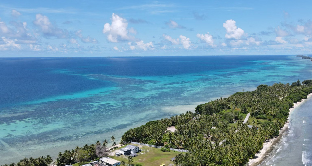 Aerial view of palm-lined Yap coastline and turquoise lagoon