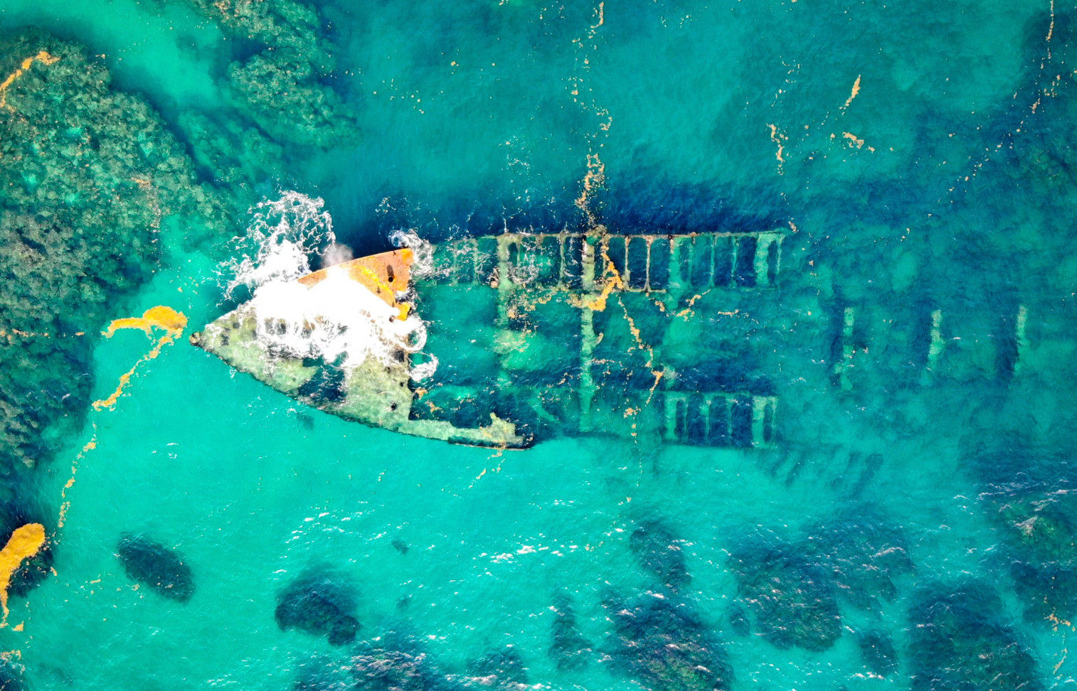 Aerial view of sunken shipwreck in clear turquoise water