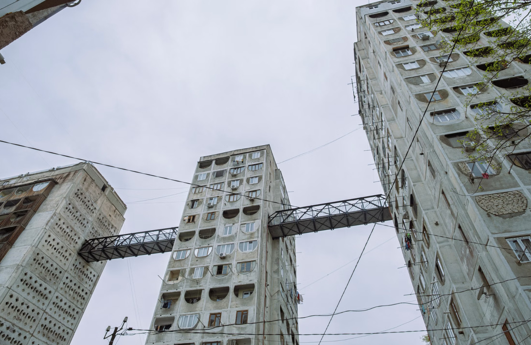 Soviet brutalist apartment towers linked by high steel skybridge