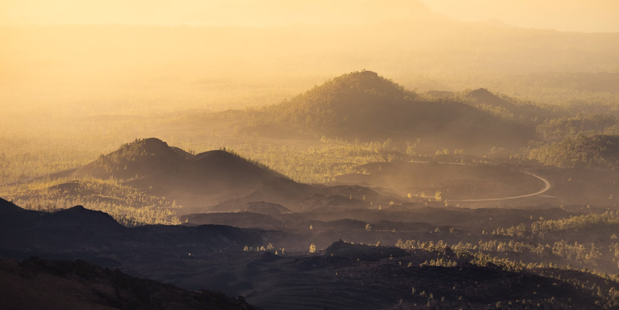 Misty volcanic hills and lava fields at golden sunrise