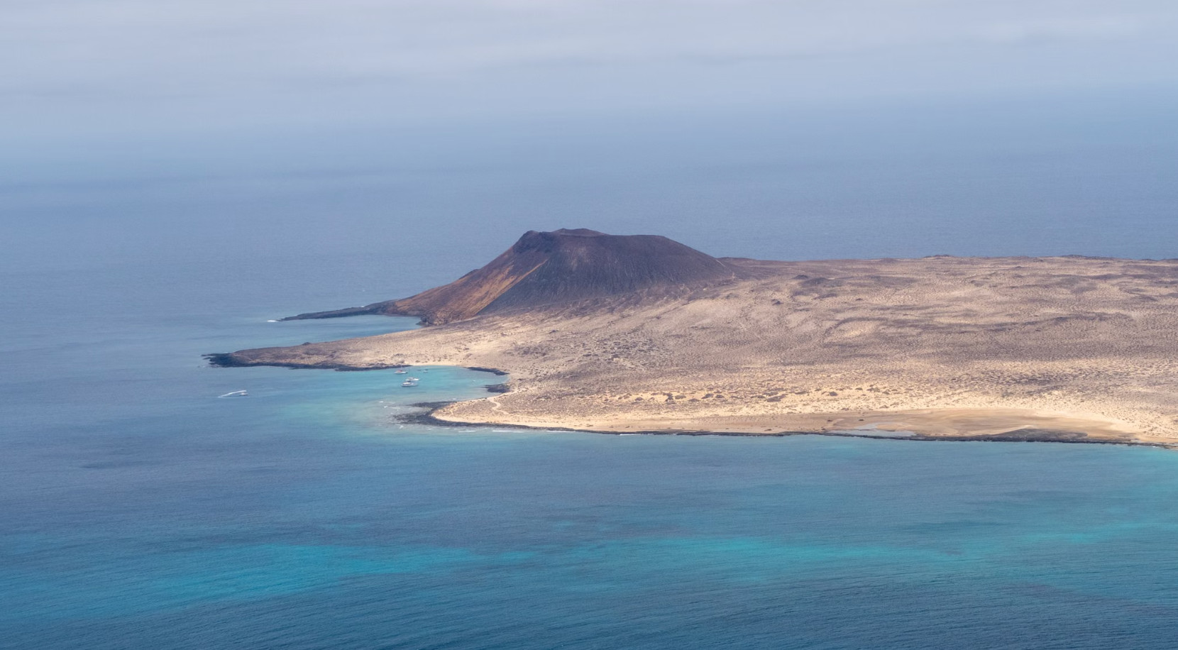 Aerial view of volcanic island coastline and turquoise water