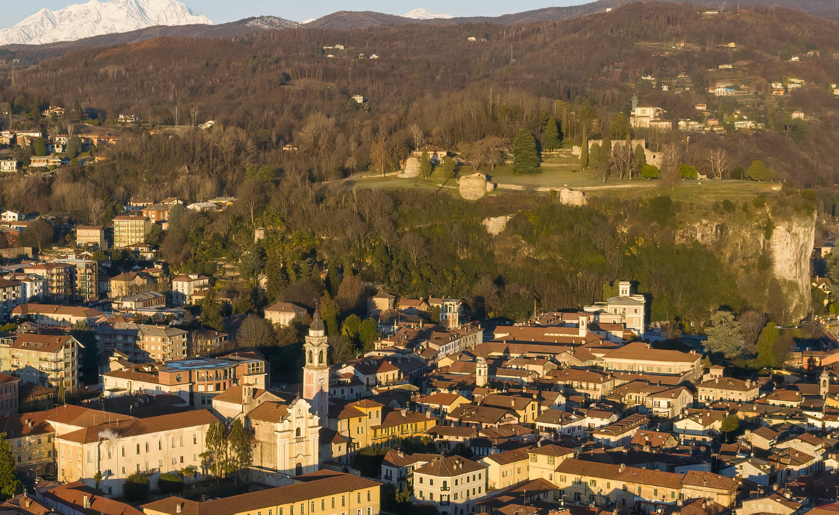 Italian hillside town and church below distant snow-capped mountains.