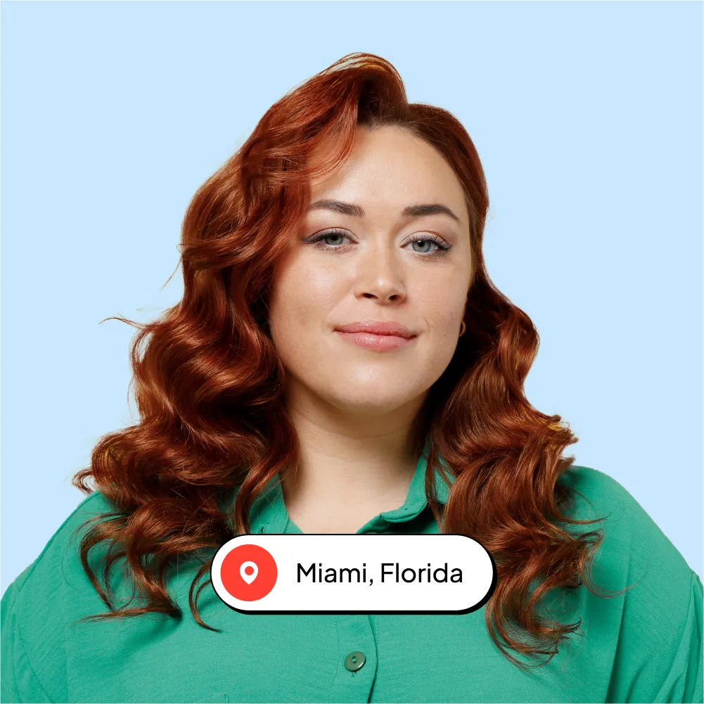 A woman with red hair is looking at the camera.