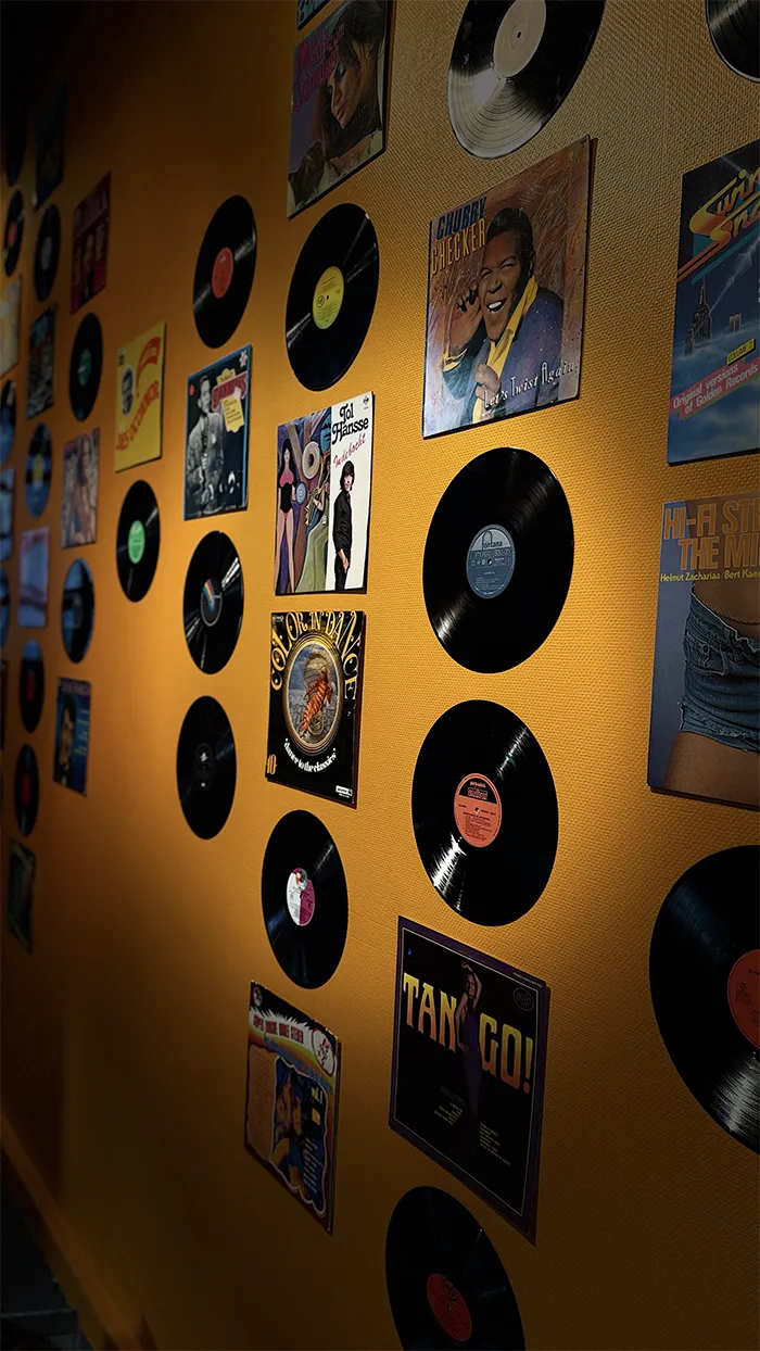 Muur met vintage lp's en platenhoezen op een gele muur