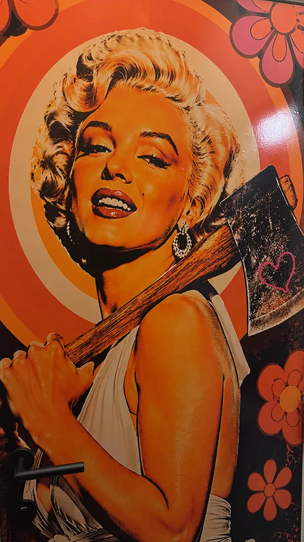 Portret van Marilyn Monroe die een brede bijl draagt met een hart erop