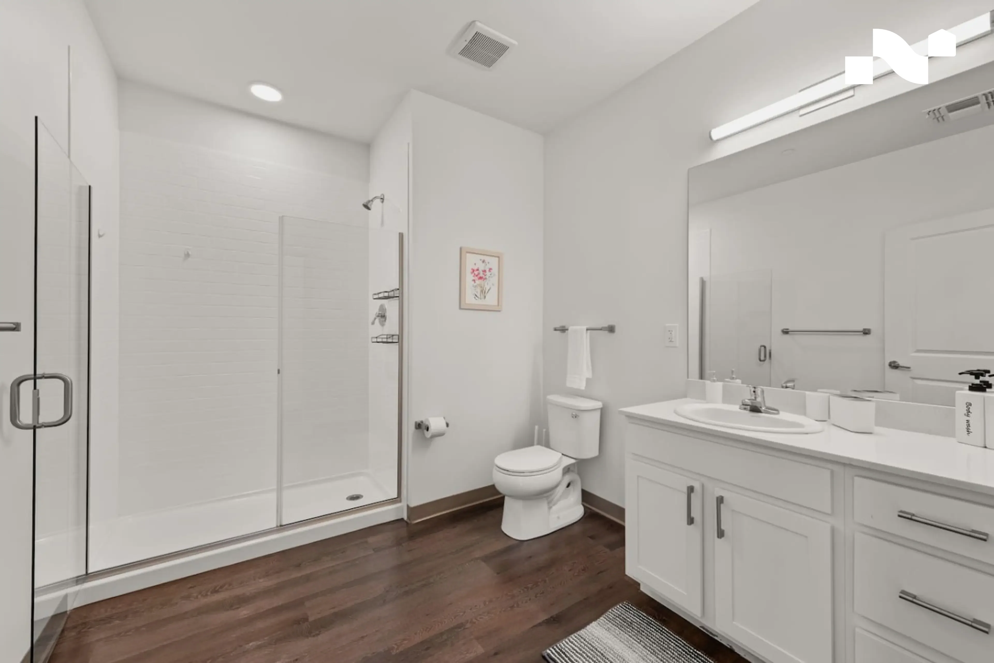 Wide walk-in shower with a low threshold and an open glass panel in a Nearwell apartment bathroom
