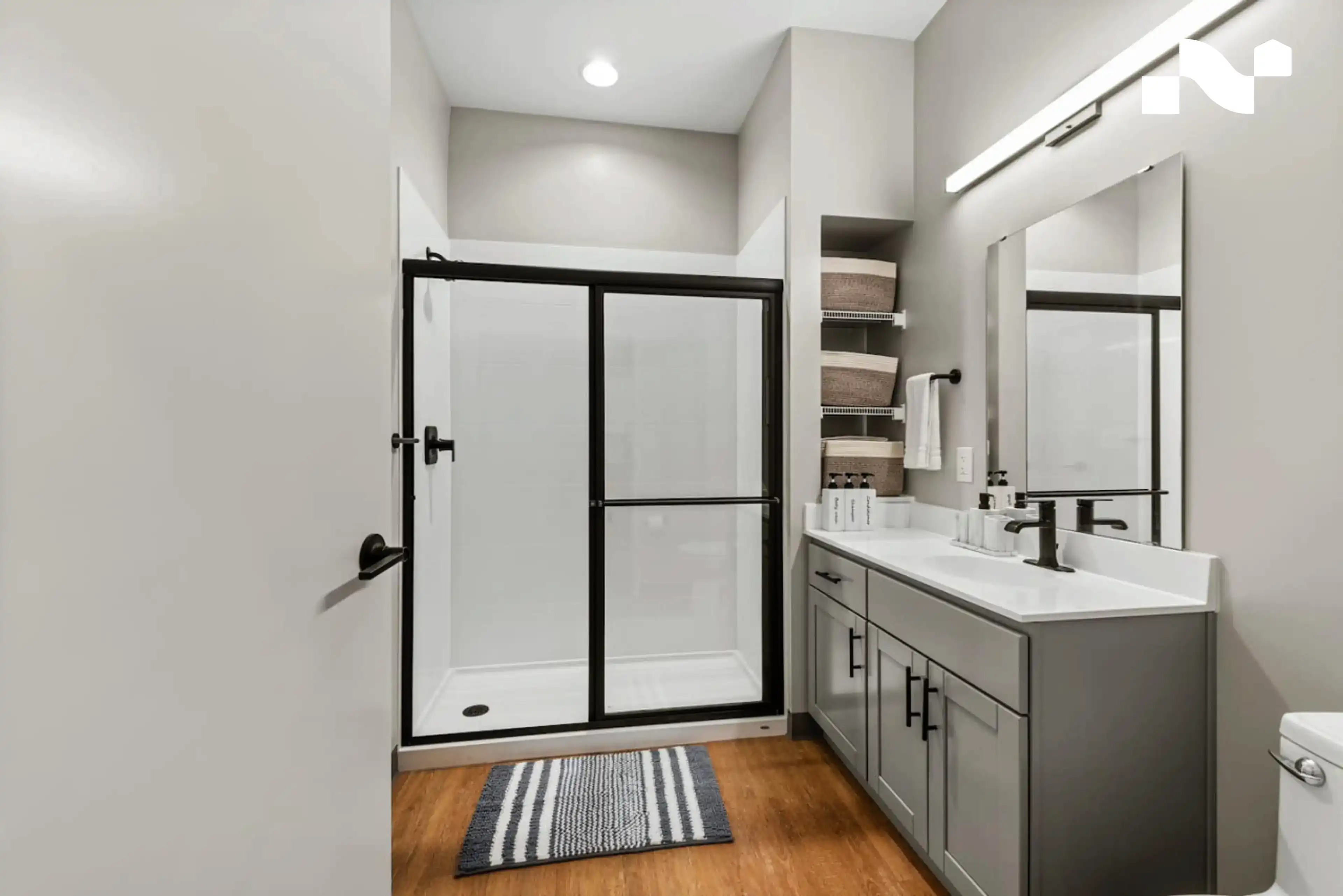 Step-in shower with a low threshold and a wide vanity in a Nearwell apartment bathroom
