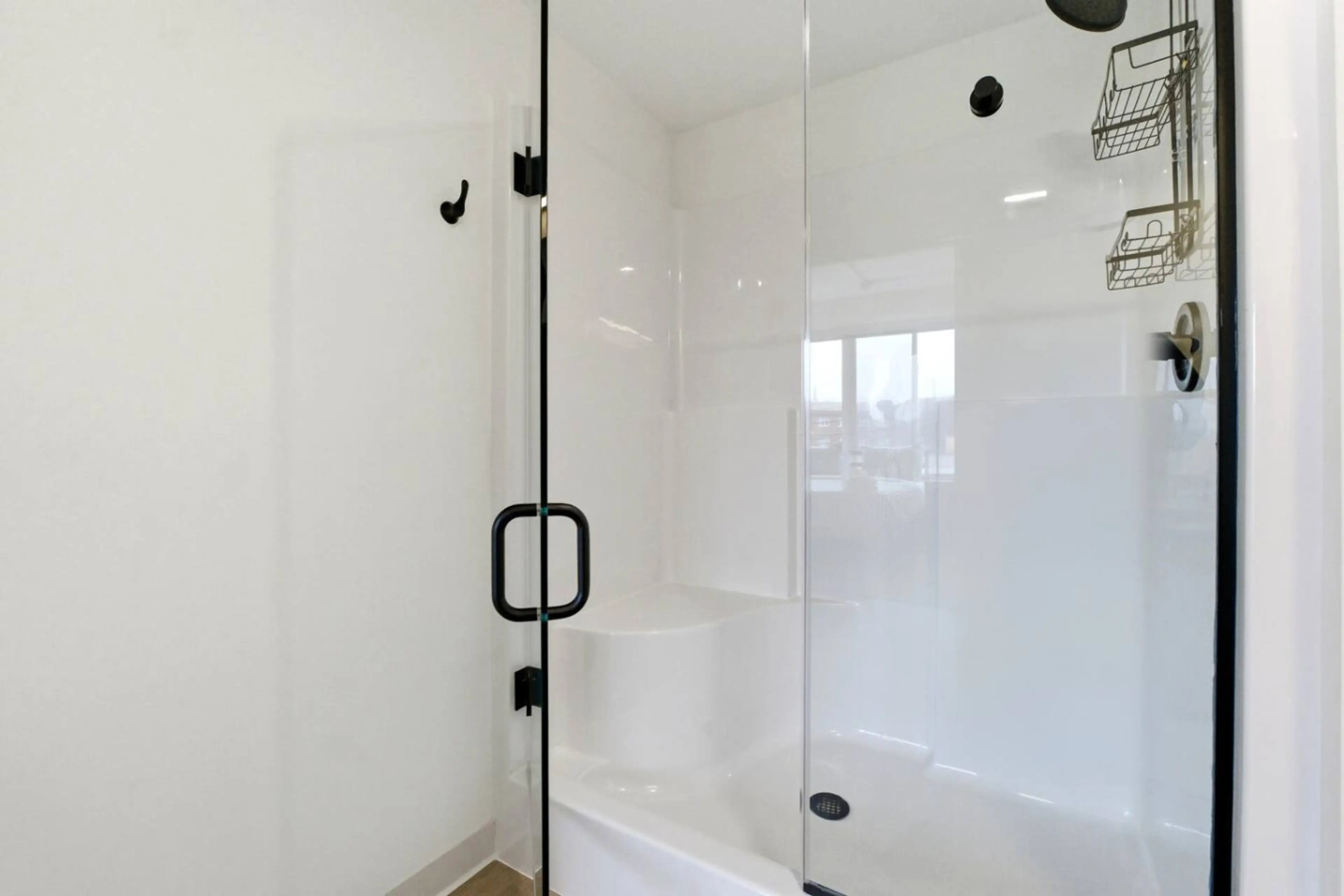 Step-in shower with a built-in seat and a glass door in a Nearwell apartment bathroom
